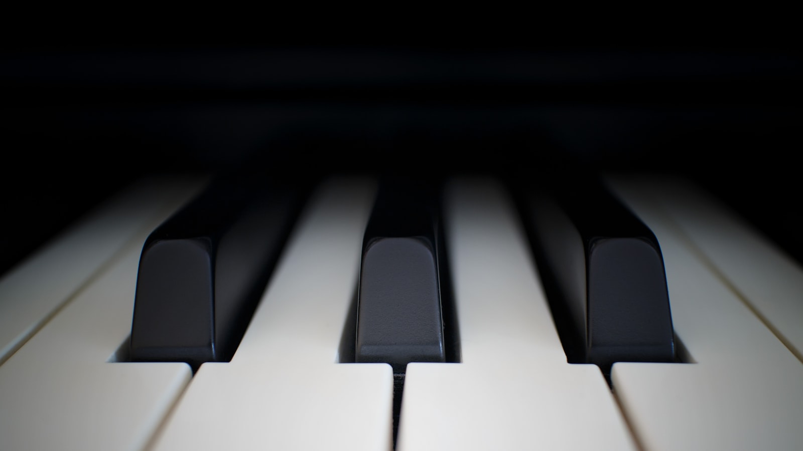A person's hands resting gently on the keys of a piano.