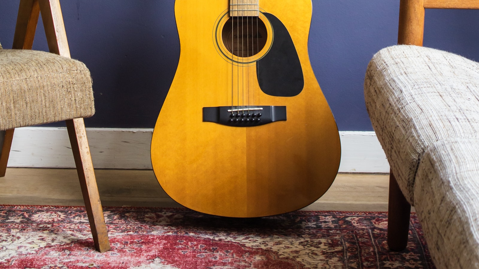 Fingertips pressing down on guitar strings near the fretboard.